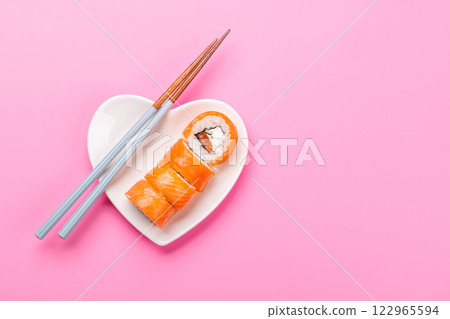 A heart-shaped plate filled with delicious sushi, accompanied by chopsticks 122965594