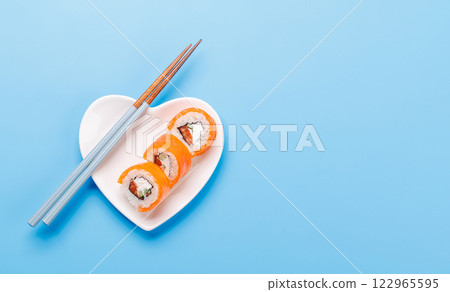 A heart-shaped plate filled with delicious sushi, accompanied by chopsticks 122965595