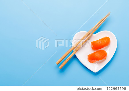 A heart-shaped plate filled with delicious sushi, accompanied by chopsticks 122965596