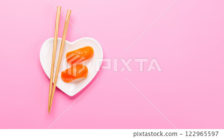 A heart-shaped plate filled with delicious sushi, accompanied by chopsticks 122965597