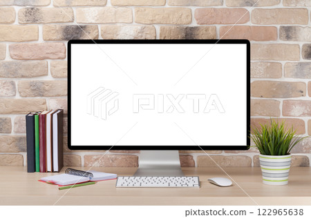 A cozy workplace setup featuring a PC with a blank screen monitor on a desk 122965638