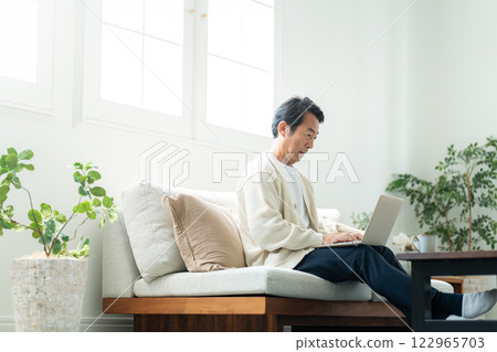 A private investor in his 50s looking at a laptop 122965703