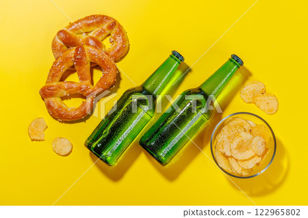 A vibrant photo showcasing bottles of beer surrounded by various snacks and fast food A vibrant photo showcasing bottles of beer surrounded by various snacks and fast food 122965802