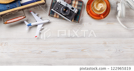 A travel bag with clothes, sun hat, flip flops, and a camera A travel bag with clothes, sun hat, flip flops, and a camera 122965819