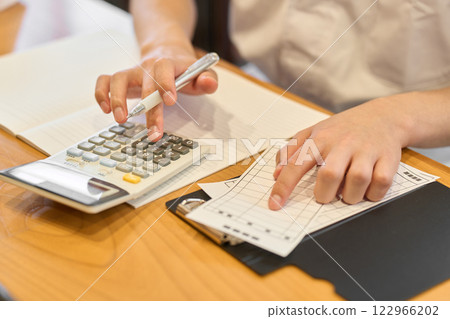 A Japanese chef working on a calculator A Japanese chef working on a calculator 122966202