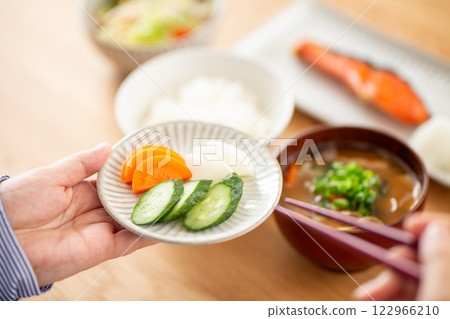 A middle-aged woman eating pickled vegetables for a Japanese breakfast A middle-aged woman eating pickled vegetables for a Japanese breakfast 122966210