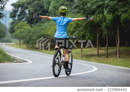 Riding bike with hands free in park 122966442
