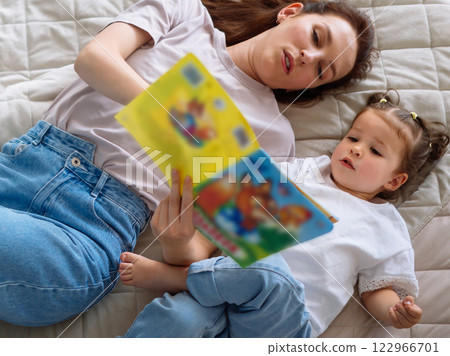 Parent young mother and young child preschool daughter reading books learning teaching story tale education fairy tales history 122966701