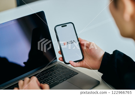 A young man in his 20s operating a smartphone New NISA 122966765