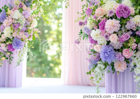 A pastel-themed outdoor wedding backdrop adorned with lush floral arrangements in soft pink, lavender, and cream hues 122967660