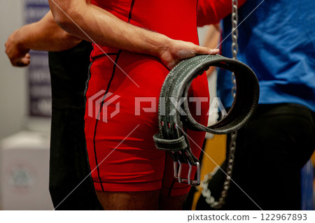 athlete dressed in red singlet powerlifting grips weightlifting belt behind my back athlete dressed in red singlet powerlifting grips weightlifting belt behind my back 122967893