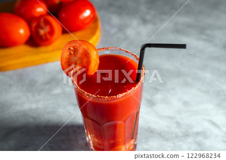 Bloody Mary cocktail in glass served with tomato slice on grey stoned surface. Red cocktail. Alternative taste. Dirty dump drink Bloody Mary cocktail in glass served with tomato slice on grey stoned surface. Red cocktail. Alternative taste. Dirty dump drink 122968234