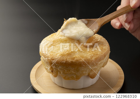 Pie stew: Lifting the pie-wrapped stew with a spoon Pie stew: Lifting the pie-wrapped stew with a spoon 122968310