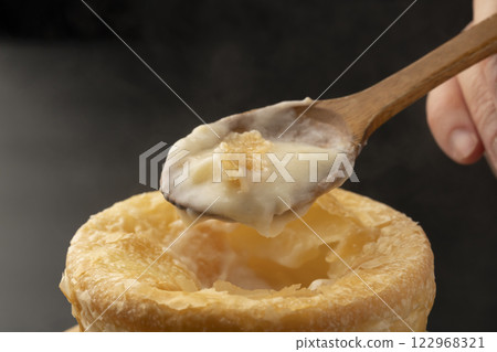 Pie stew: Lifting the pie-wrapped stew with a spoon 122968321