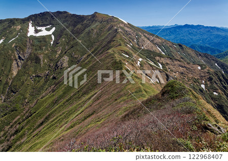 View of the summit of Mt. Tanigawa, Mt. Hotaka in Joshu, and Mt. Nikko Shirane from the Tanigawa Mountain Range traverse trail in early summer 122968407