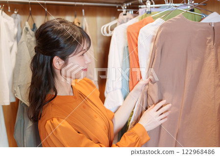 一位女士在步入式衣櫥裡挑選衣服(時尚搭配) 一位女士在步入式衣櫥裡挑選衣服(時尚搭配) 122968486