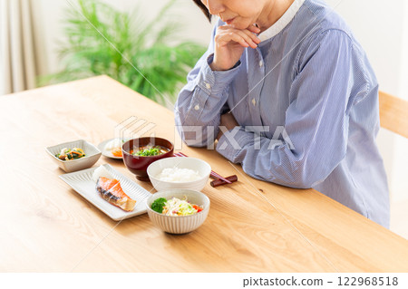A middle-aged woman worried about her Japanese breakfast 122968518