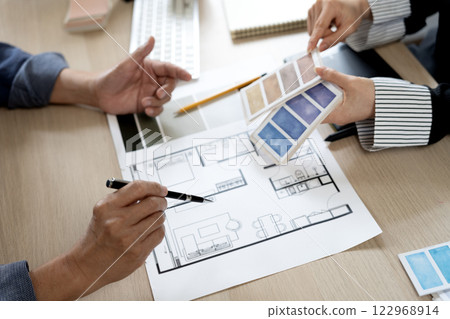 Young businesswoman and business man are brainstorming to select material Young businesswoman and business man are brainstorming to select material 122968914