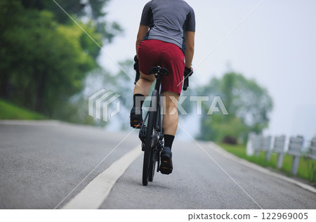 Asian woman cycling on summer trail 122969005