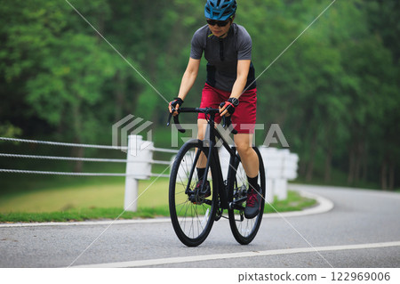 Asian woman cycling on summer trail Asian woman cycling on summer trail 122969006