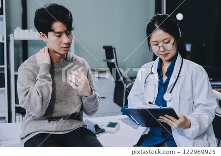 Female physician reads medical history while visiting her patient 122969925