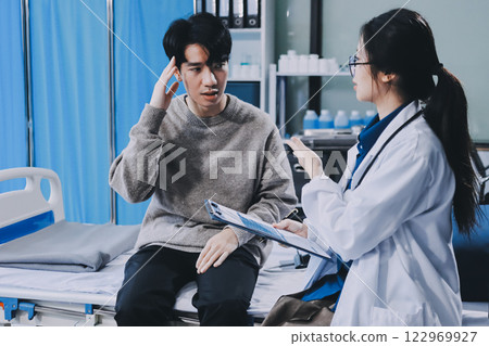 Female physician reads medical history while visiting her patient 122969927