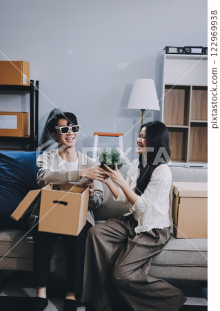 Smiling couple unpacking boxes in new house 122969938