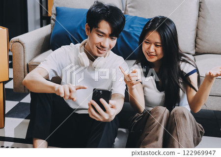 Smiling couple unpacking boxes in new house 122969947