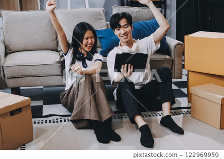 Smiling couple unpacking boxes in new house 122969950
