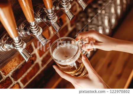 A Refreshing and Delicious Beer Being Skillfully Poured at a Charming Rustic Bar Setting 122970802