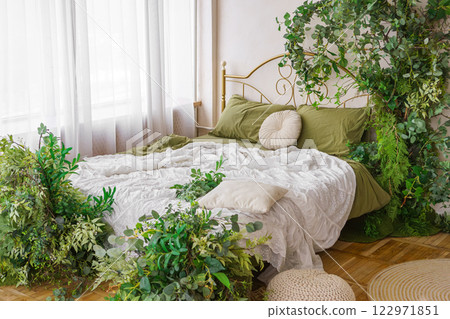 Cozy bedroom adorned with lush greenery and natural spring decor for tranquil atmosphere 122971851