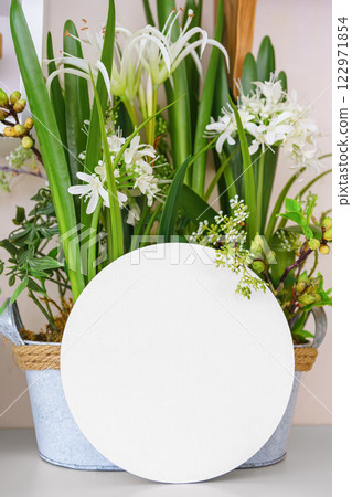 Beautiful arrangement of vibrant flowers in decorative pot with empty display paper circle 122971854