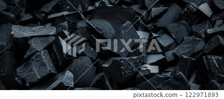 Black volcanic stone. Surface of basalt or granite close-up. Dark rough and textured rock. 122971893