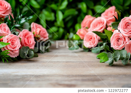 A bunch of pink roses sitting on top of a wooden table 122972277