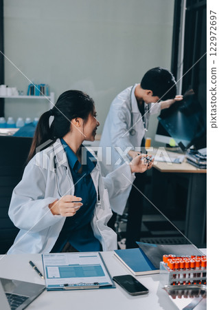 Positive doctor working on laptop in medical office, portrait. Positive doctor working on laptop in medical office, portrait. 122972697