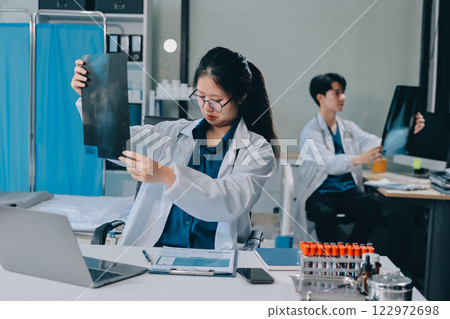 Positive doctor working on laptop in medical office, portrait. 122972698