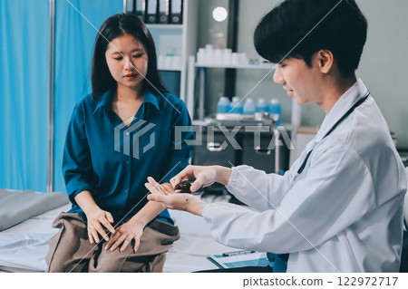 doctor consulting senior old patient filling form at consultation. Professional physician wearing white coat talking to mature woman signing medical paper at appointment visit in clinic. doctor consulting senior old patient filling form at consultation. Professional physician wearing white coat talking to mature woman signing medical paper at appointment visit in clinic. 122972717