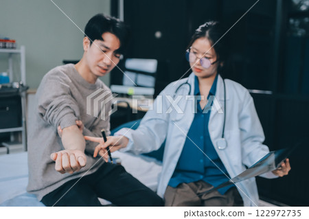 Female physician reads medical history while visiting her patient 122972735