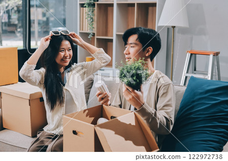 Smiling couple unpacking boxes in new house 122972738