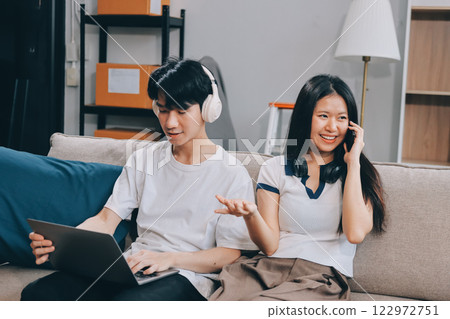 Smiling couple unpacking boxes in new house 122972751
