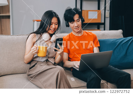 Smiling couple unpacking boxes in new house 122972752
