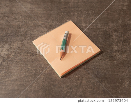 Note pad and pencil on a wooden table Note pad and pencil on a wooden table 122973404
