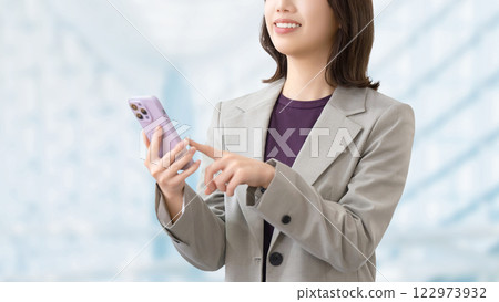 使用智慧型手機的微笑的女人/女商人 122973932