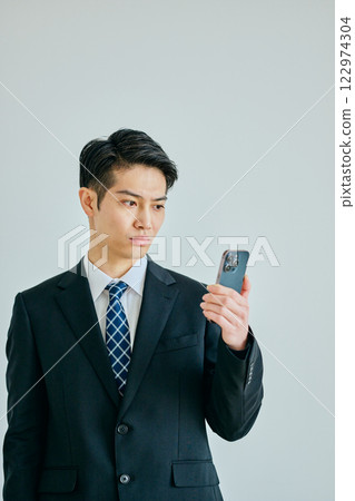 一名二十多歲的年輕人拿著智慧型手機 122974304