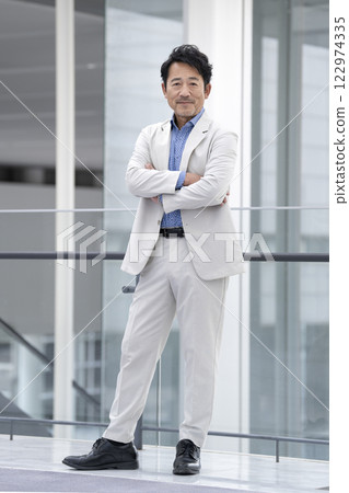 一名 50 多歲的男子交叉雙臂，面帶微笑，看著鏡頭 122974335