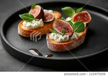 Minimalist food presentation featuring figs and cheese on toasted bread Minimalist food presentation featuring figs and cheese on toasted bread 122975836