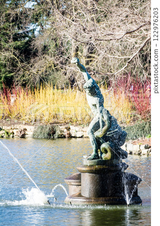 A Greek mythical figure of a man and a giant snake surrounded by a fountain at Kew Gardens on the outskirts of London 122976203
