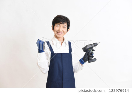 一位身穿圍裙的年輕女子正在做 DIY 一位身穿圍裙的年輕女子正在做 DIY 122976914