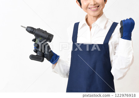 A young woman in an apron doing DIY A young woman in an apron doing DIY 122976918