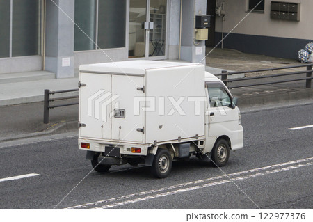 Delivery truck driving on road 122977376